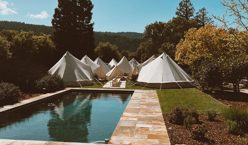 Furnished canvas bell tents set up for a group event